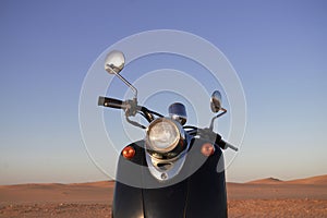 The Retro scooter at sunset in the golden sand of the Namib Desert