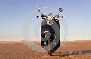 The Retro scooter at sunset in the golden sand of the Namib Desert