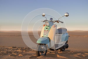 Retro scooter at sunset in the golden sand of the Namib Desert