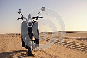 The Retro scooter at sunset in the golden sand of the Namib Desert