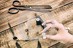 Retro silver coin in women`s hand. Tools to create vintage money by coinage. Reconstruction of ancient tools for making coins