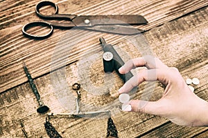 Retro silver coin in women`s hand. Tools to create vintage money by coinage. Reconstruction of ancient tools for making coins photo