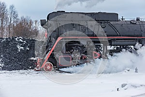 Retro steam locomotive before coal loading at winter morning