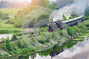 Retro steam train moves along the lake