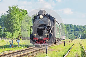 Retro steam train moves in the forest