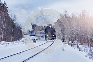 Retro steam train moves at winter day.