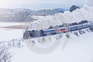 Retro steam train moves at winter morning