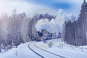 Retro steam train moves at winter morning