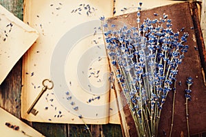 Retro still life with vintage books, key and lavender flowers, nostalgic composition on wooden table top view.