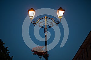 Retro street lamp in the city park at summer sunset.