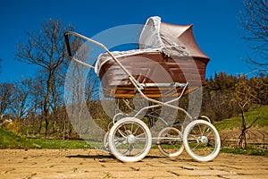 Retro style baby carriage outdoors on sunny day