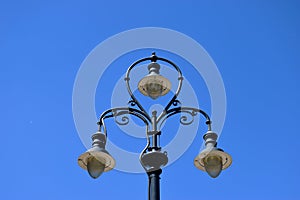 Retro style black iron street lamp post with white glass lamps