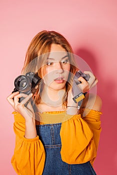 Retro style fashionable woman with film camera on pink background