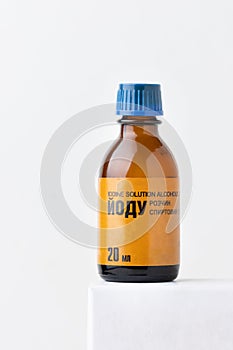 Retro style glass bottle with medical iodine on white background. Close up of brown glass bottle with alcohol solution of iodine
