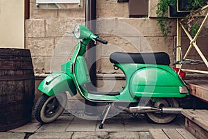 Retro style green scooter on Lviv street. Exterior, restaurant design. Modep left outdoors