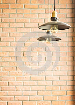 Retro style incandescent bulb lamp in vintage coffee shop with brick wall background