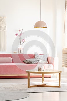 Retro style, millennial pink pendant lamp above a simple, wooden