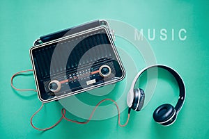 Retro style old  boombox radio from 1950s, 1960s and headphones on green pastel paper background .Vintage tone instagram style