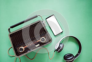 Retro style old boombox radio from 1950s, 1960s and headphones, technology mobile phone blank white space for your text on green