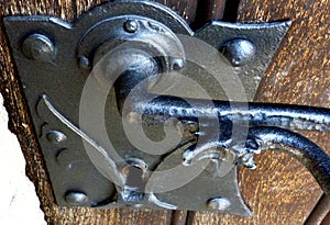 Iron retro classical door handle and lock on old wooden door