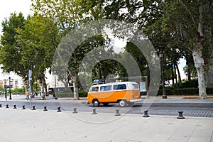 Retro style orange van on holiday in any city in the world. Travel and holidays concept