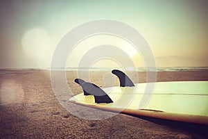 surfboard on beach at sunset photo