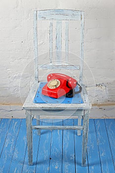 Retro style - Red vintage phone, old chair