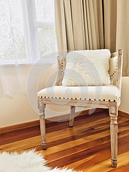 A retro-style room chair next to the window with beige curtains. Interior Design. photo