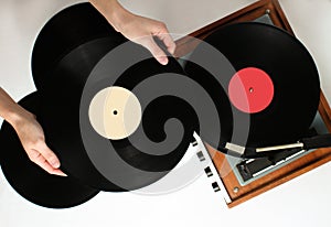 Retro style, woman hands holding vinyl record, vinyl player