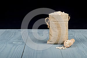 Retro style wooden background. There is a small bag on it, it is barley. Place for your text. Copy space