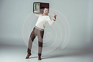 retro styled handsome man posing with vintage television