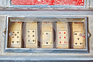 Close up of a weathered vintage slot machine with playing cards