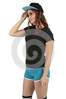 Retro styled sports model wearing a blank black t-shirt and blue running shorts teamed up with a baseball cap