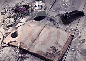Retro styled still life with old diary, black candle and mystic objects