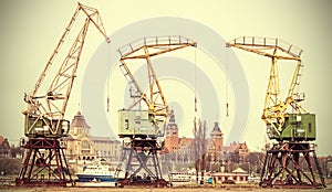Retro stylized picture of cranes in Szczecin City.