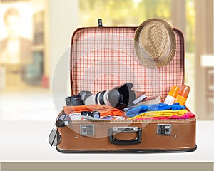 Retro suitcase with travel objects on background