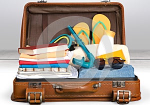 Retro suitcase with travel objects on grey