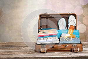 Retro suitcase with travel objects on wooden