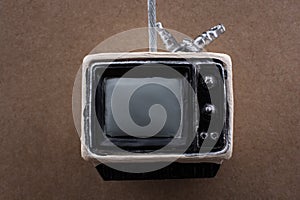 Retro syled tiny television model on brown background