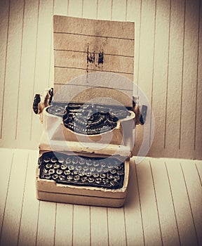 Retro syled tiny typewriter model on paper