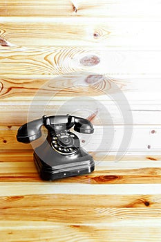 Retro telephone on wooden background.