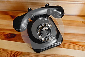 Retro telephone on wooden background.