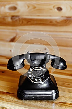 Retro telephone on wooden background.