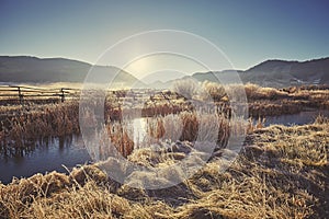 Retro toned foggy and frosty morning over lake in Grand Teton Na