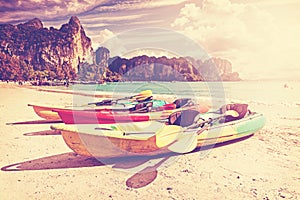 Retro toned kayaks on a tropical beach.