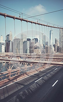 Retro toned picture of New York cityscape seen through Brooklyn Bridge cables, USA