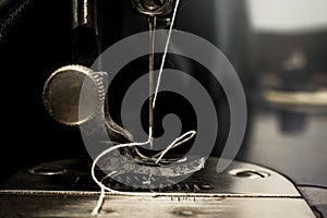 Retro tools for cutting and sewing. Needle with thread, thimble, sewing machine and scissors