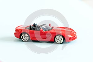 Retro toy car detail. Red toy car with an open top on a white background. convertible toy, the concept of renting a car