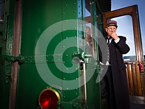 Retro train conductor in antique train