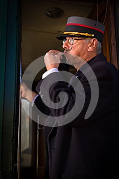 Retro train conductor blowing whistle